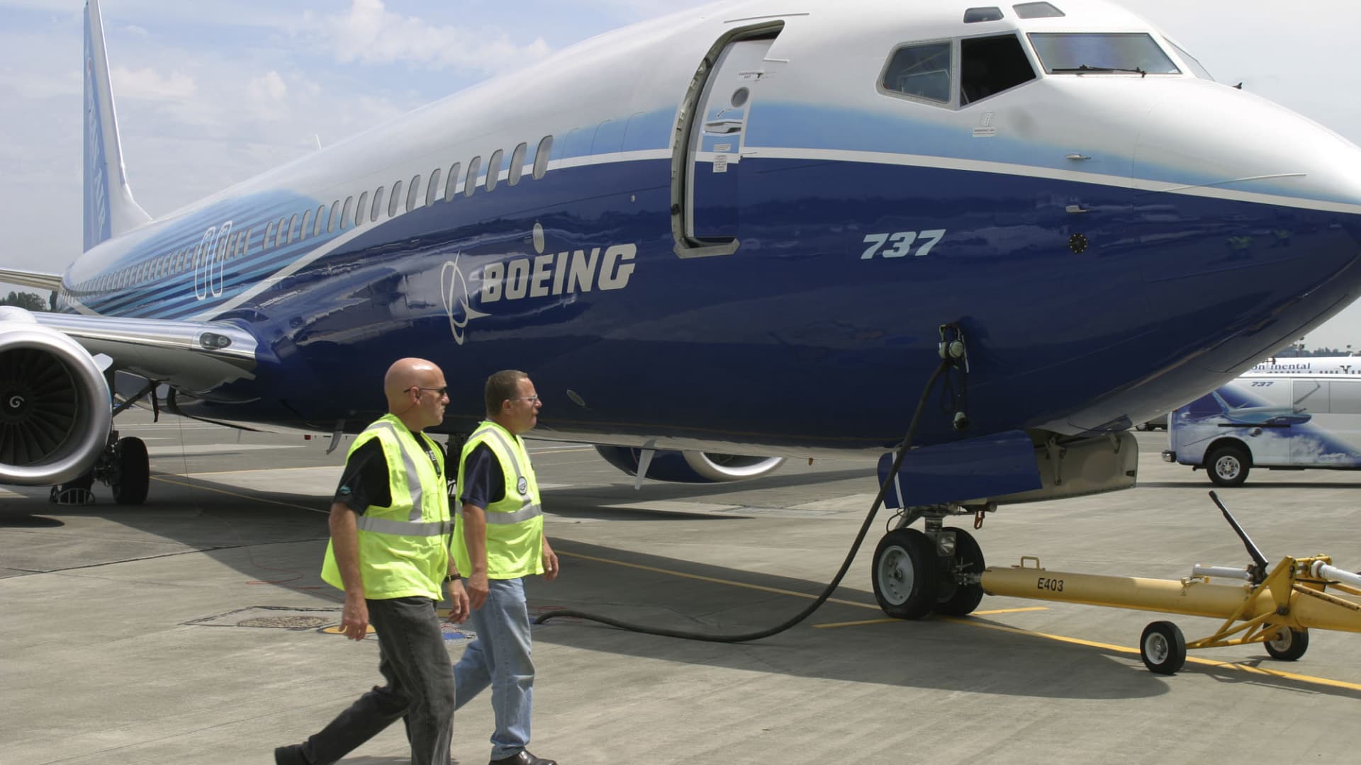 Boeing employees walk by a new Boeing 737-900 at Boeing Field in Seattle.