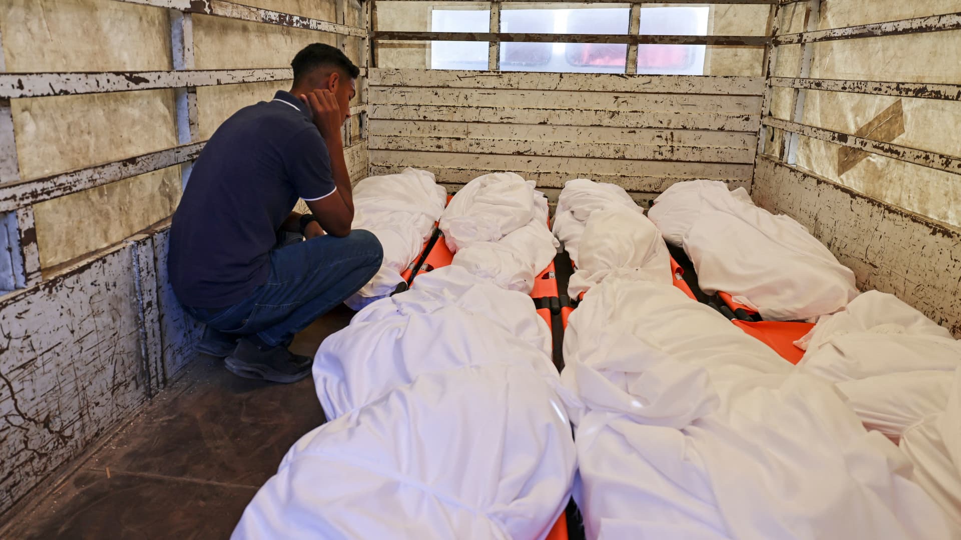 A Palestinian man mourns over the bodies of member of the Kawlak family, who were killed in an Israeli airstrike overnight on Gaza City's Rimal residential district, during preparations for their burial outside the Al-Shifa Hospital on May 16, 2021.