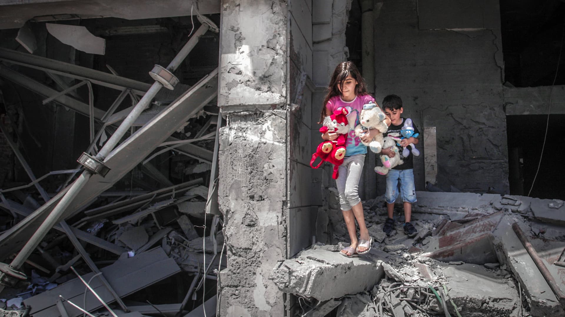 Palestinian children salvage toys from their home at the Al-Jawhara Tower in Gaza City, on May 17, 2021, which was heavily damaged in Israeli airstrikes.