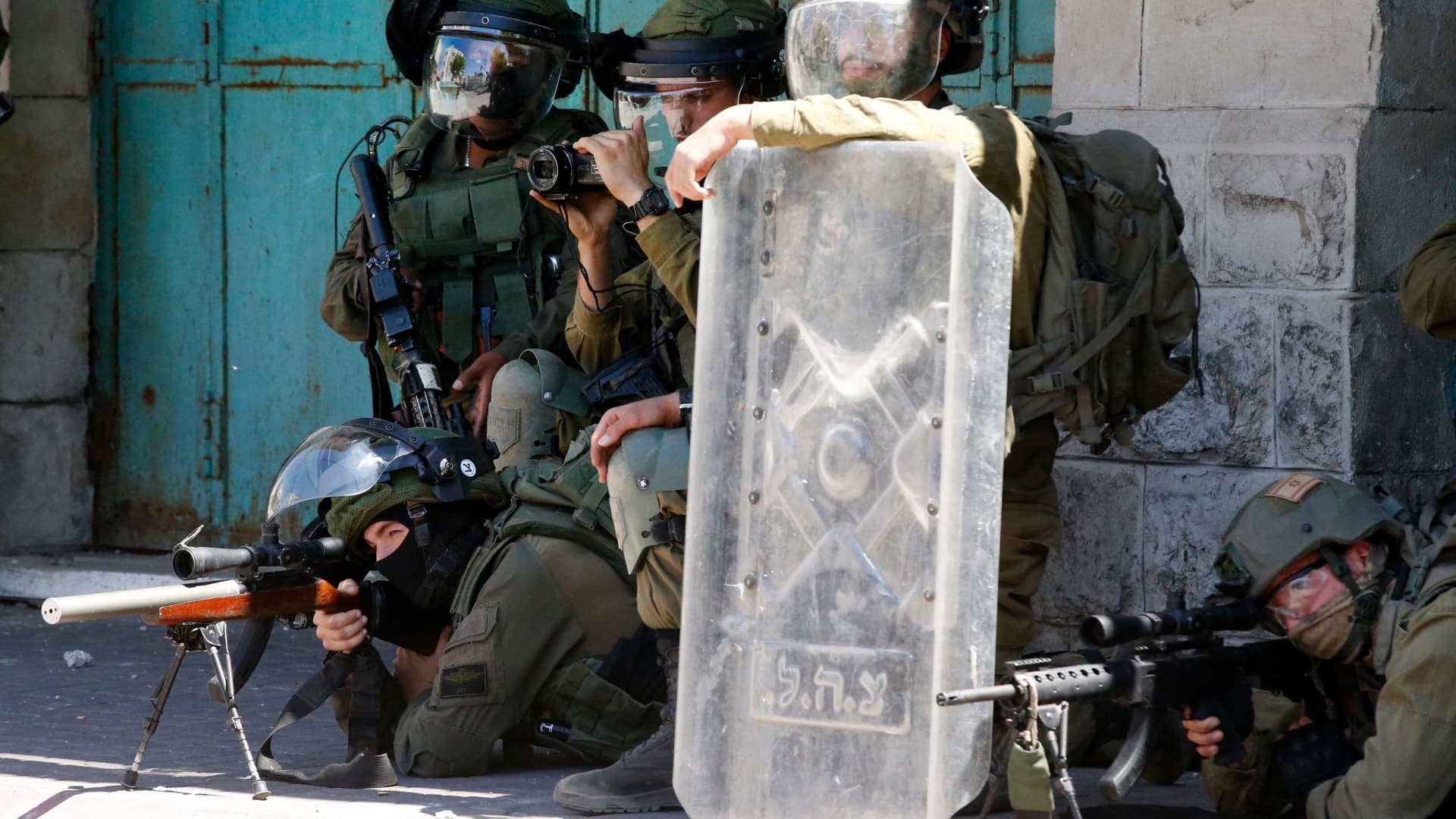 Israeli security forces take aim at Palestinian demonstrators during protests against Israel's occupation and its air campaign on the Gaza strip, in the occupied West Bank town of Hebron May 18, 2021.