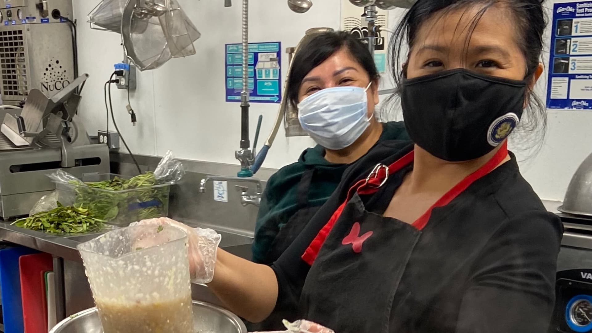 Jan-Ie Low (right) and volunteer Huong Pham pack hot meals to help feed families in need for Operation #MoveForwardTogether in Fountain Valley, California on Feb. 21, 2021.