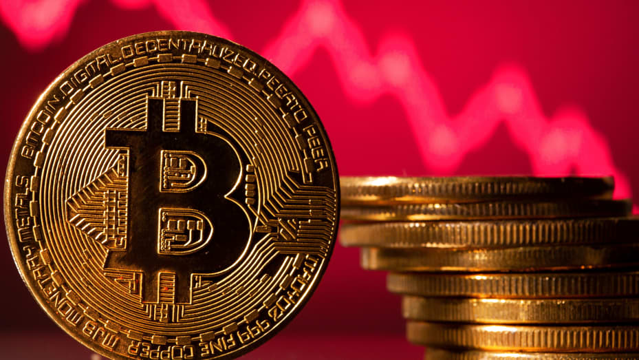 A representations of virtual currency Bitcoin is seen in front of a stock graph in this illustration taken May 19, 2021.