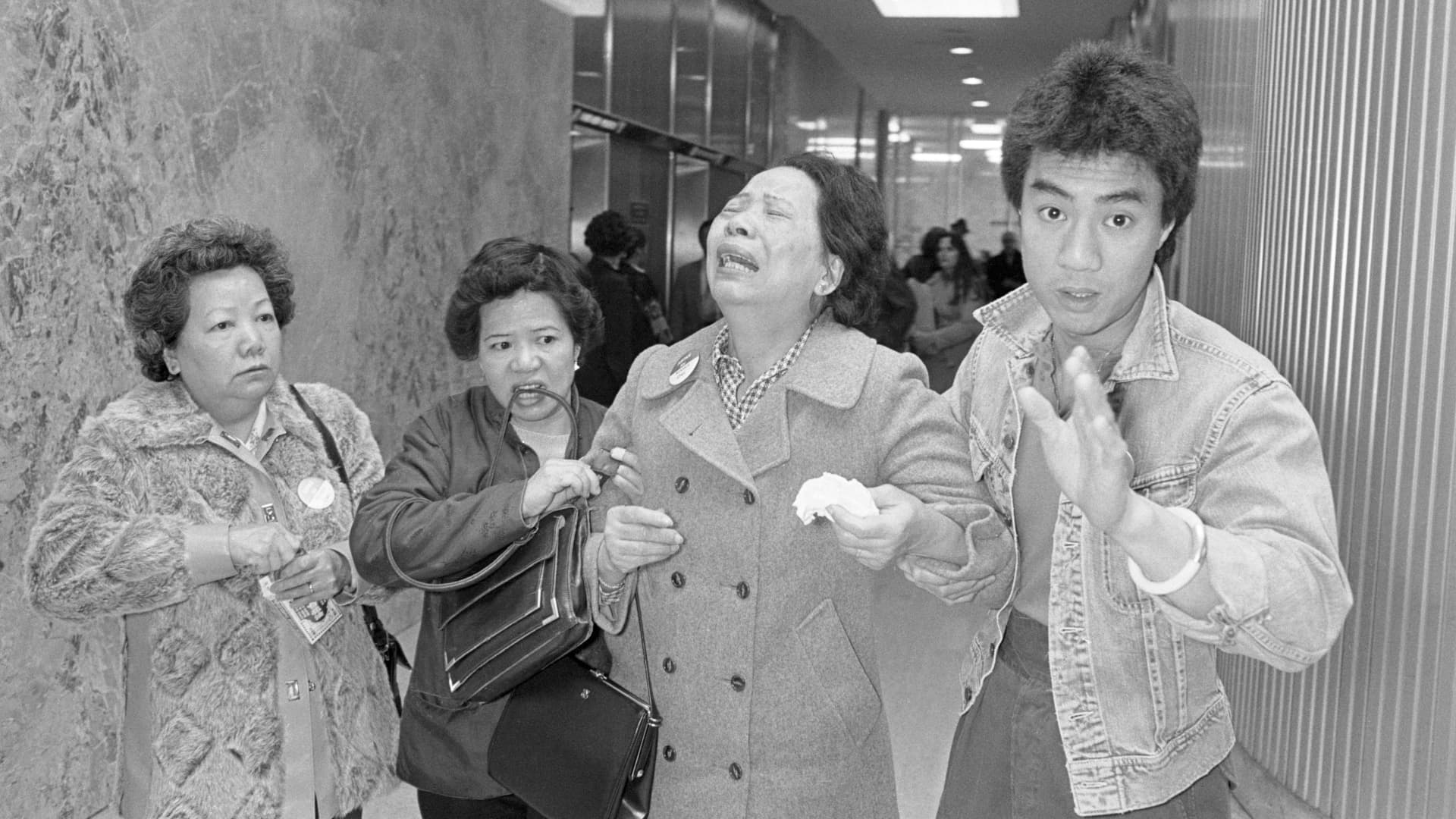 Lillie Chin, mother of Vincent Chin who was clubbed to death by two white men in June 1982, breaks down as a relative (L), helps her walk while leaving Detroit's City County Building in April, 1983.