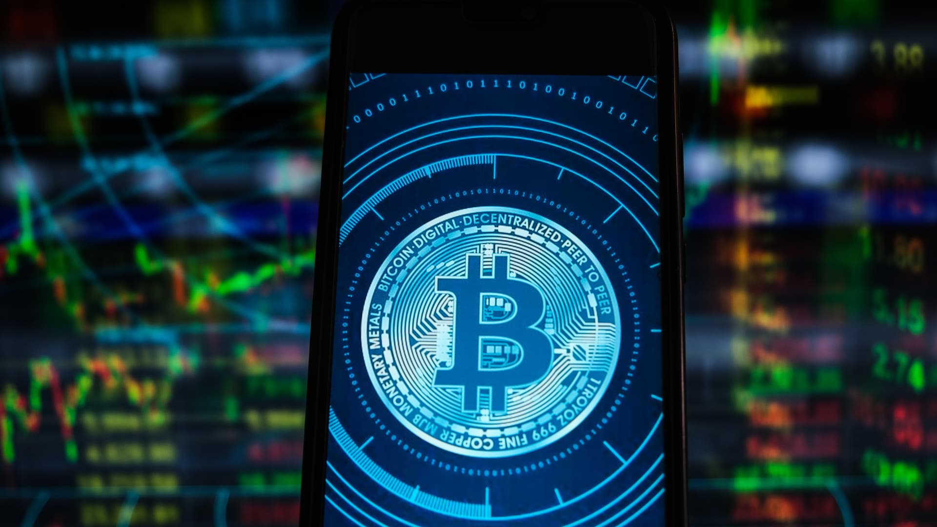 A Bitcoin logo seen displayed on a smartphone with stock market percentages in the background in this illustration taken April 26, 2021.