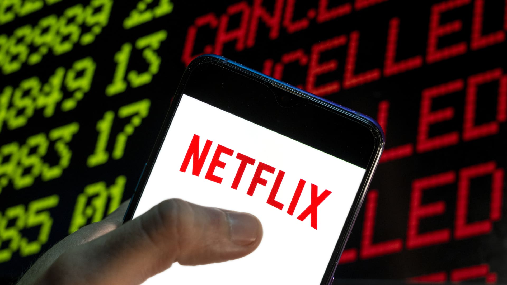 In this photo illustration the American global on-demand Internet streaming media provider Netflix logo is seen on an Android mobile device with the word cancelled on a computer screen.
