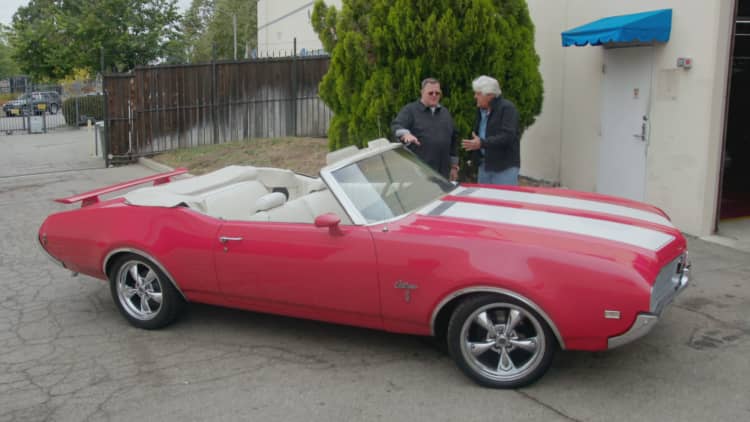 Jay Leno and Billy Gardell reminisce about old times in an Oldsmobile Cutlass