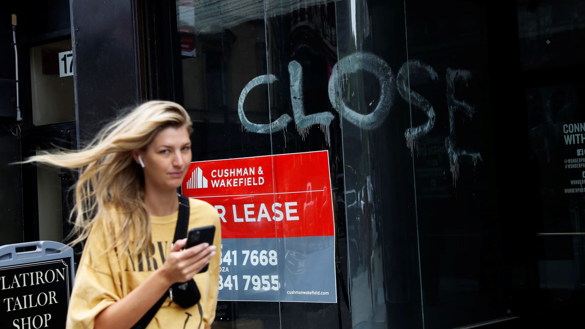 A woman walks by a closed retail store in the Flatiron district of New York City, U.S., May 28, 2021.