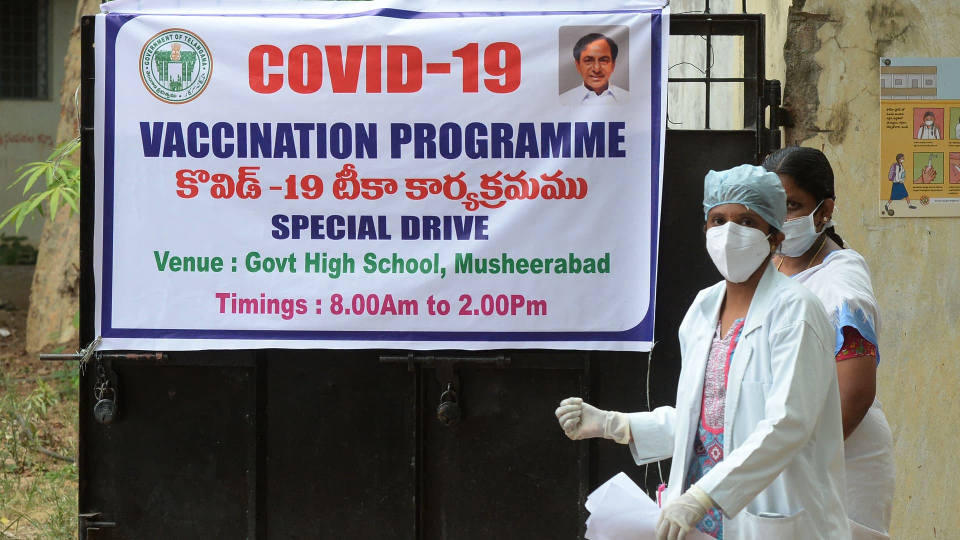 A doctor walks past the banner announcing a Covid-19 vaccination drive in Hyderabad, India on May 28, 2021.