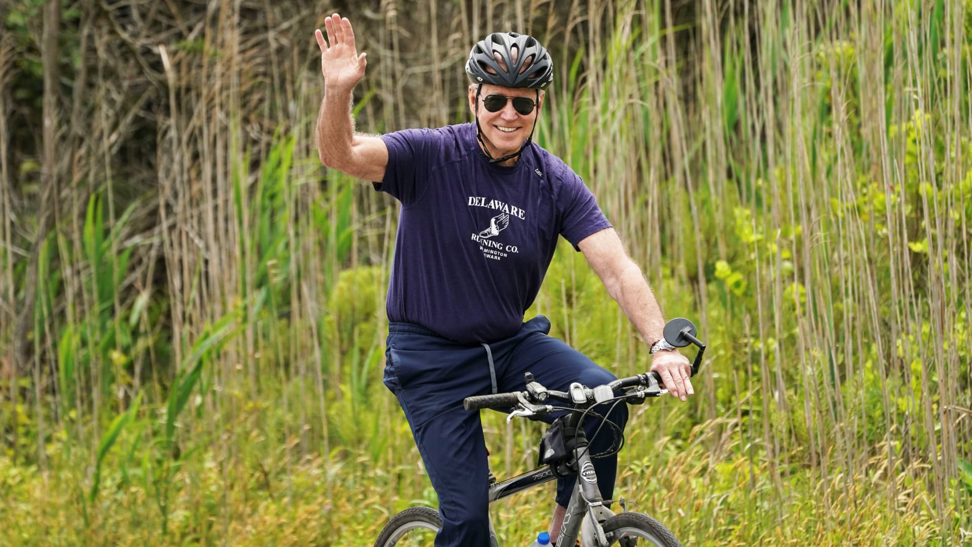 U.S. President Joe Biden waves from his bike while riding at Cape Henlopen State Park in Rehoboth Beach, Delaware, June 3, 2021.