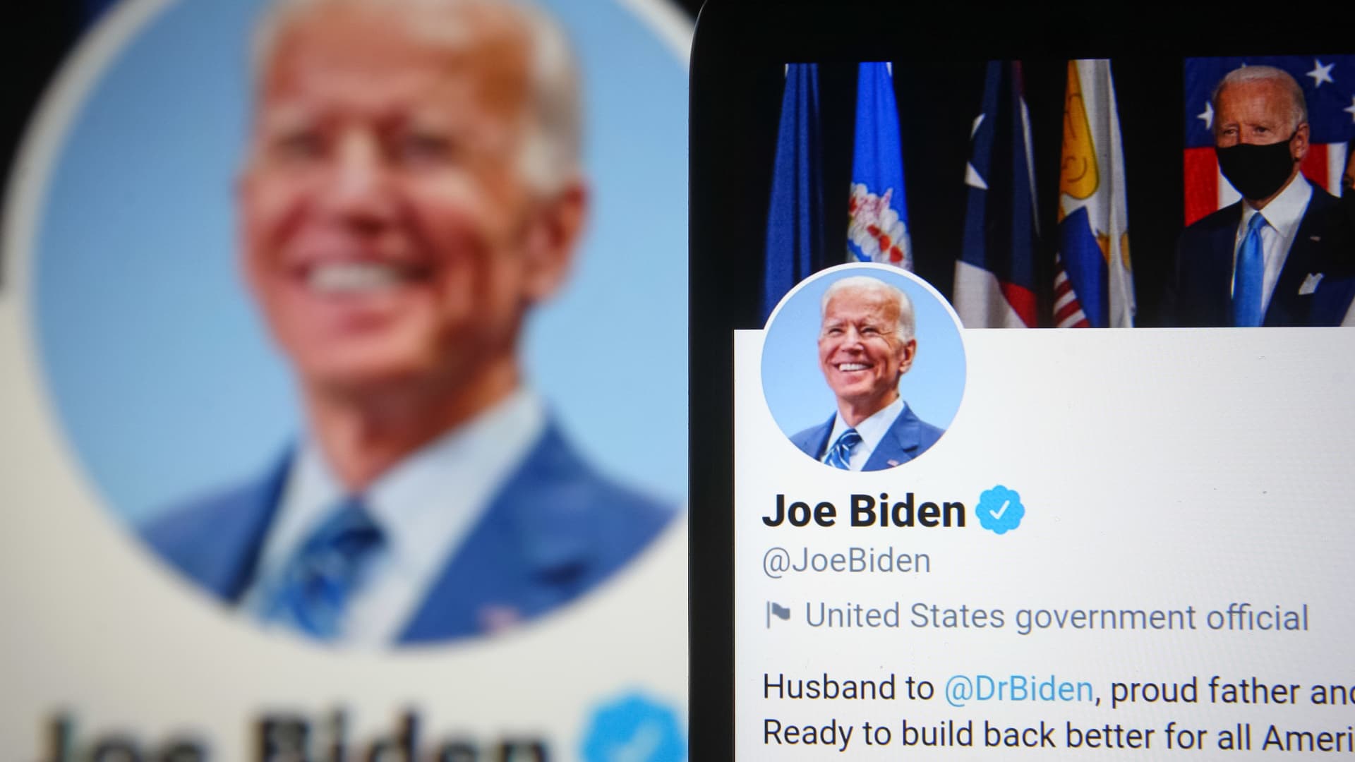 Twitter account of U.S. President Joe Biden is seen on a smartphone and a pc screen in the background.