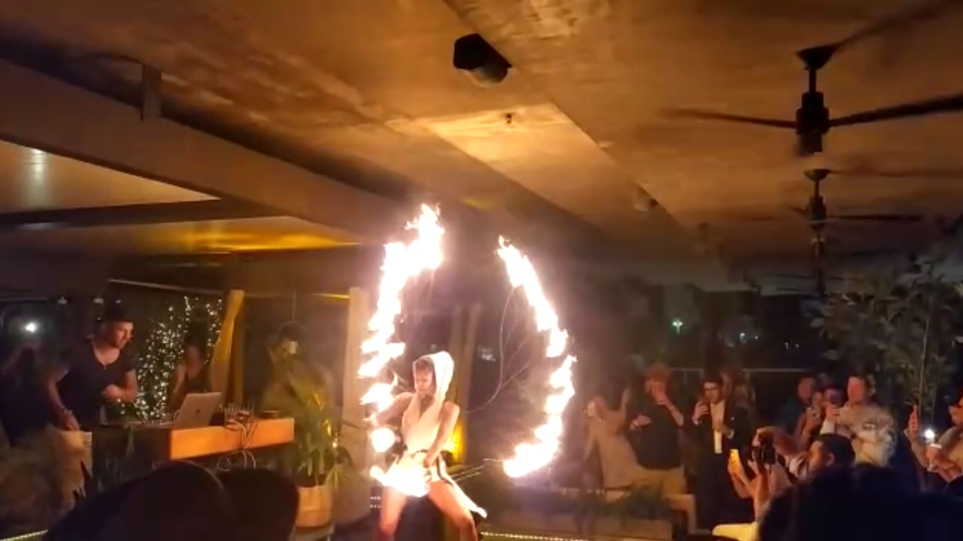 Fire dancers entertain crypto enthusiasts at a rooftop party in Miami.