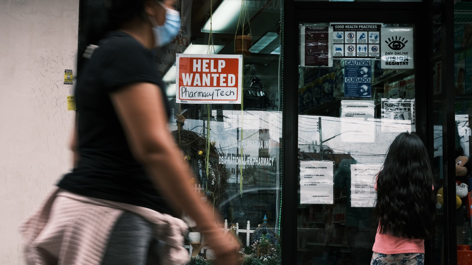 People walk by a Help Wanted sign in the Queens borough of New York City on June 04, 2021 in New York City.