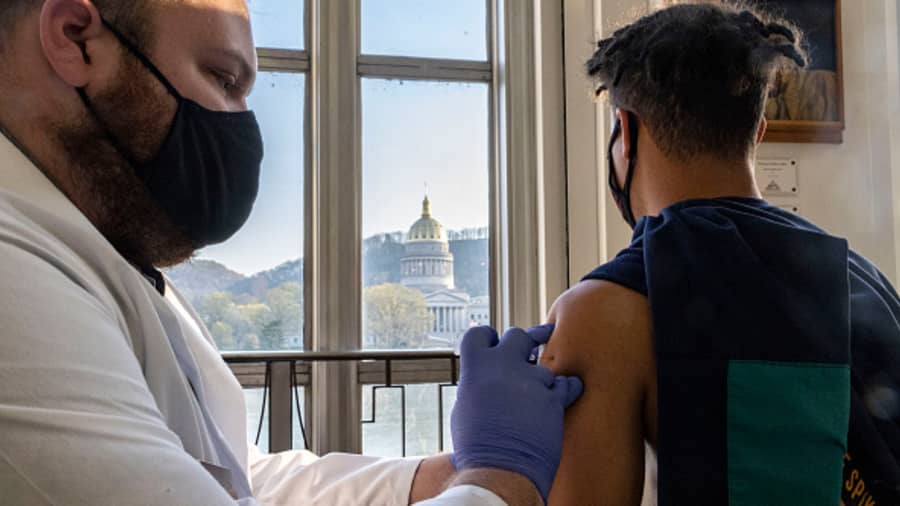 A young man in West Virginia receives the vaccine while overlooking the West Virginia Capitol Building in Riggleman Hall.