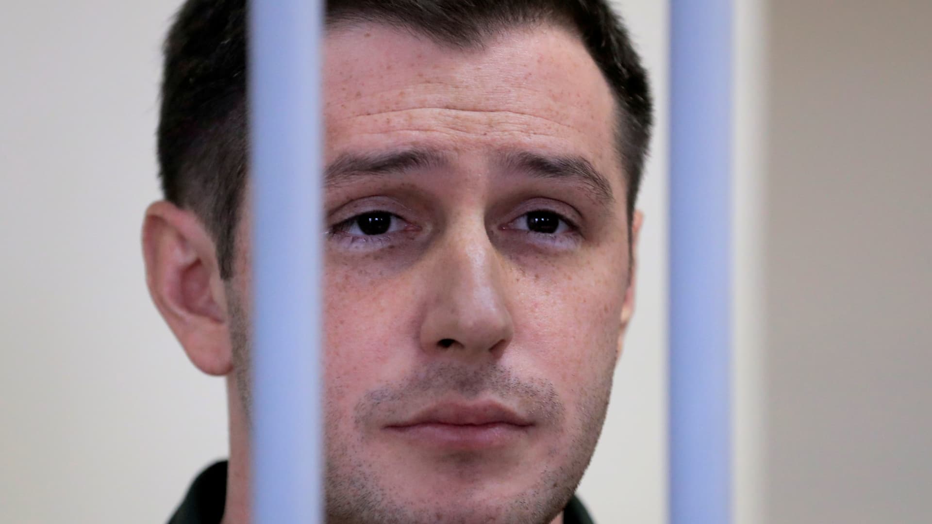 Former U.S. Marine Trevor Reed, who was detained in 2019 and accused of assaulting police officers, stands inside a defendants' cage during a court hearing in Moscow, Russia March 11, 2020.