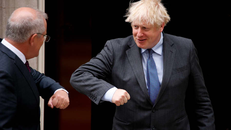 British Prime Minister Boris Johnson (R) elbow-bumps a greeting with Australian Prime Minister Scott Morrison (L) in the doorway of 10 Downing Street in London, United Kingdom on June 14, 2021.
