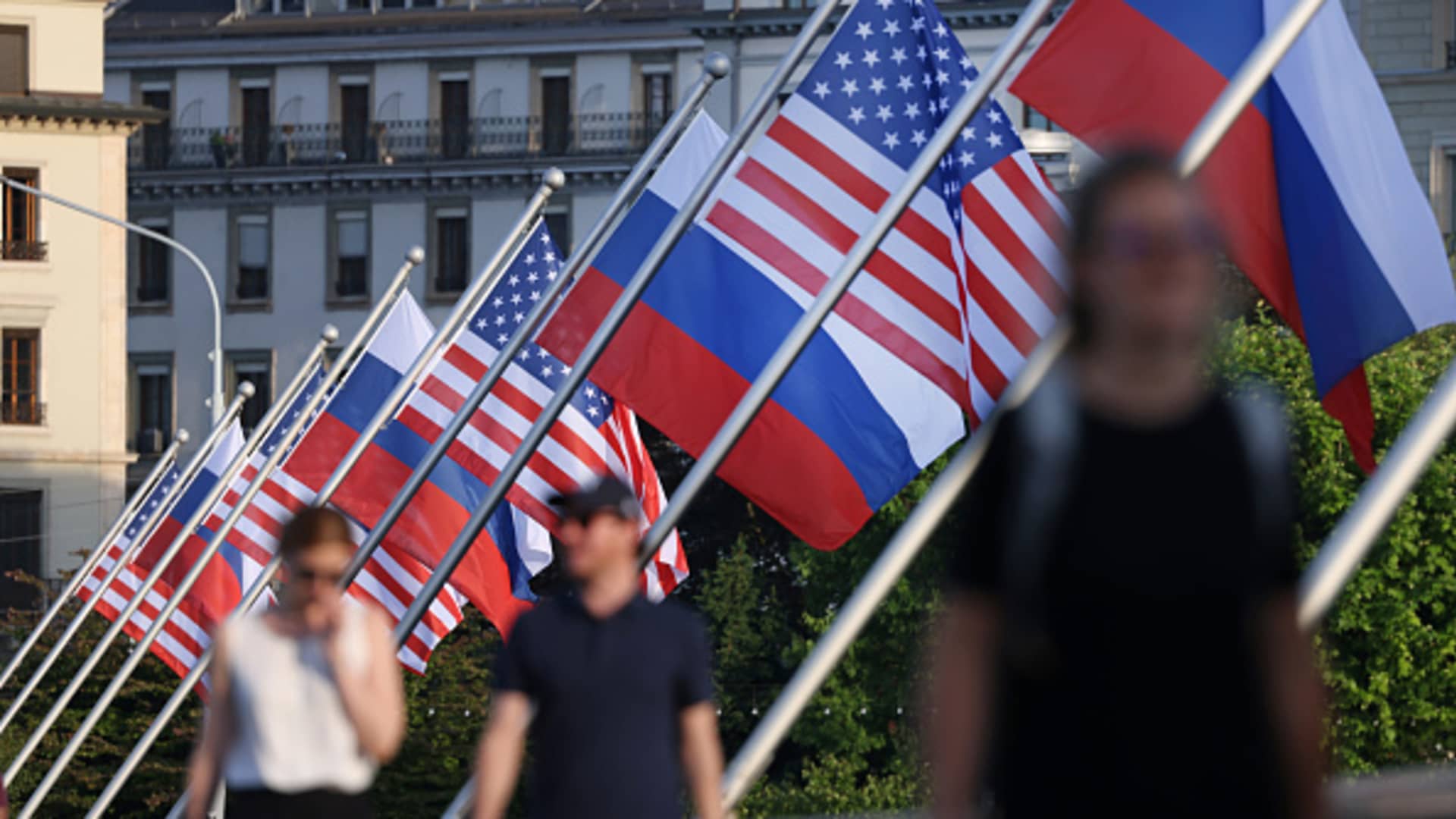 People walk under Russian and American flags on a bridge in the city center prior to a meeting between U.S. President, Joe Biden and Russian President, Vladimir Putin on June 15, 2021 in Geneva, Switzerland.