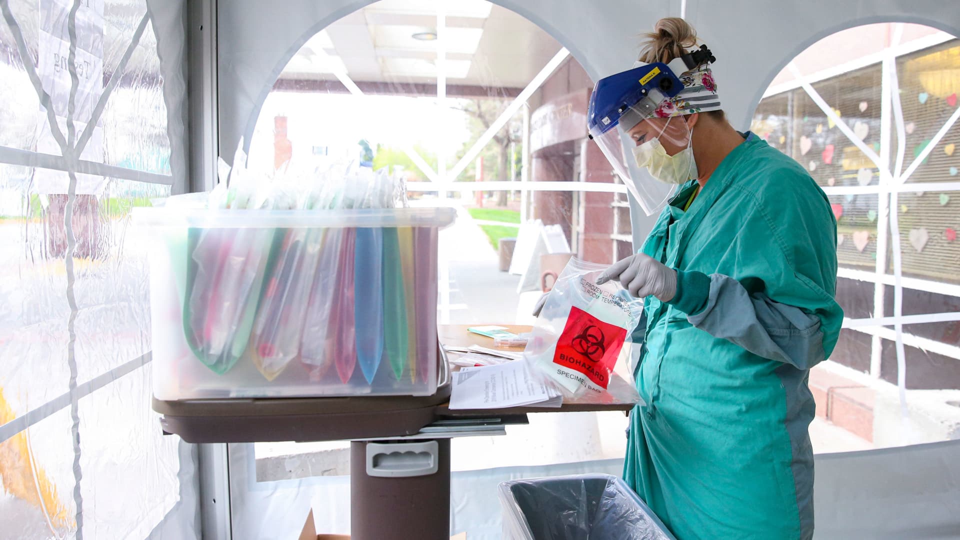Medical assistant Katrina Rogers opens a biohazard bag used to seal coronavirus test swab specimens at the University of Iowa Hospitals and Clinics Family Medicine Clinic, Monday, April 20, 2020, in Iowa City, Iowa.