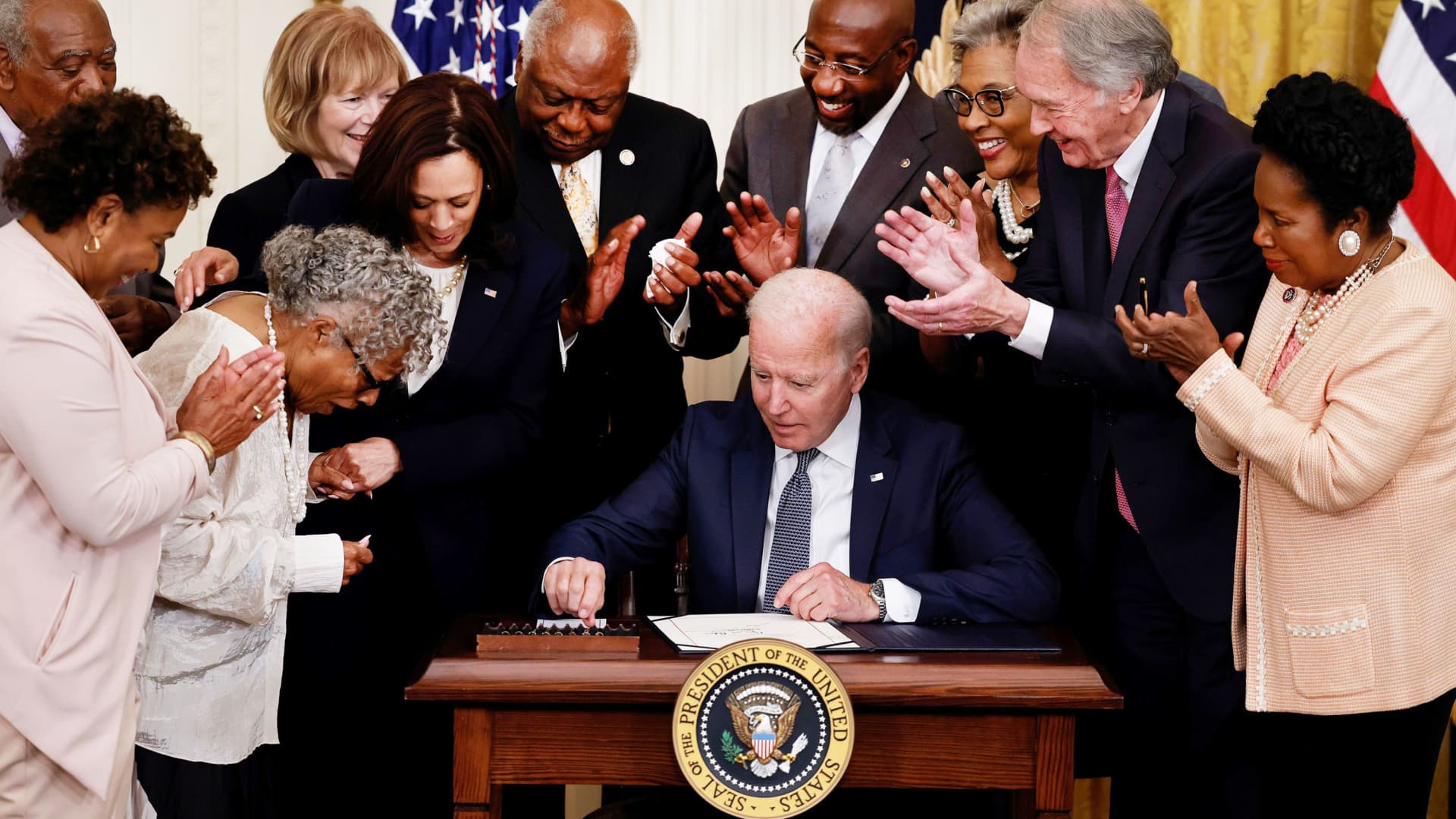 U.S. President Joe Biden is applauded as he reaches for a pen to sign the Juneteenth National Independence Day Act into law as Vice President Kamala Harris stands by in the East Room of the White House in Washington, June 17, 2021.