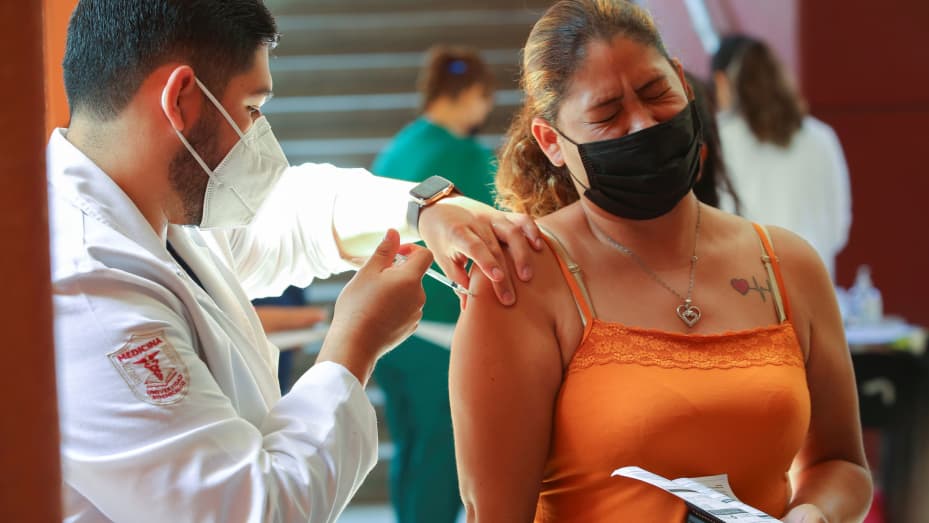 A woman reacts as she receives the Johnson & Johnson vaccine against the coronavirus disease (COVID-19), as part of a government plan to inoculate Mexican border residents on its shared frontier with the United States, in Tijuana, Mexico June 17, 2021.