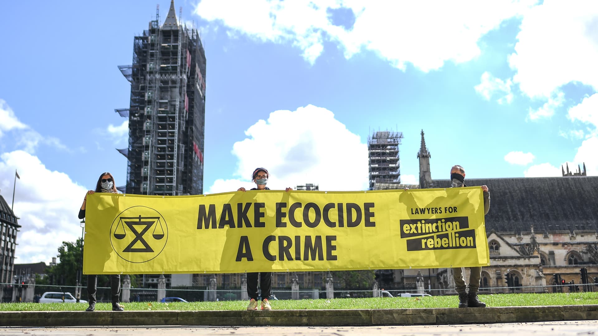 Members of Extinction Rebellion hold a banner reading 'Make Ecocide a Crime' in Parliament Square on August 28, 2020 in London, England.
