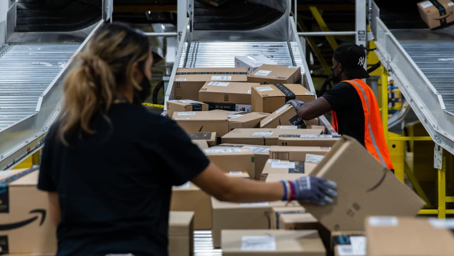 Workers retrieve boxes at an Amazon fulfillment center on Prime Day in Raleigh, North Carolina, U.S., on Monday, June 21, 2021.