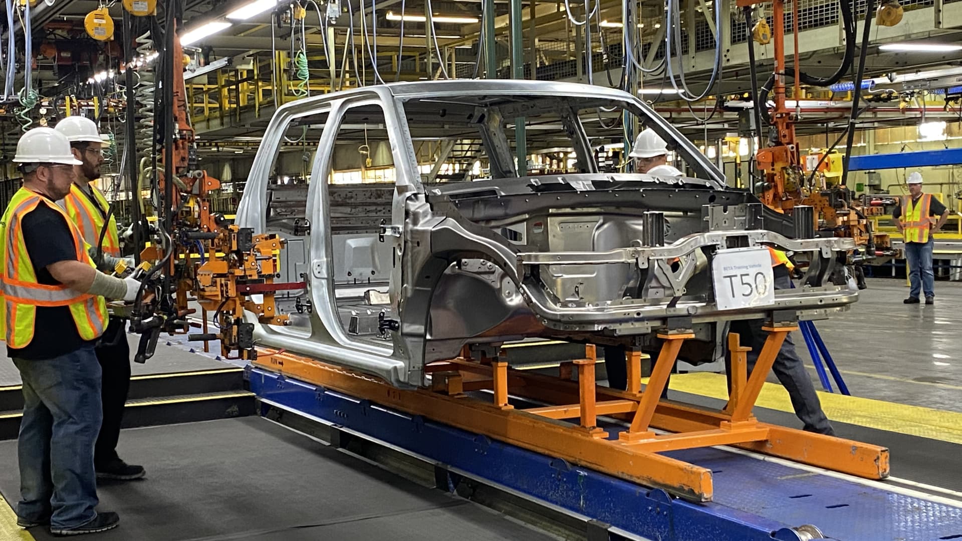 Workers install door hinges to the body shell of a prototype Endurance electric pickup truck on June 21, 2021 at Lordstown Motors' assembly plant in Ohio.