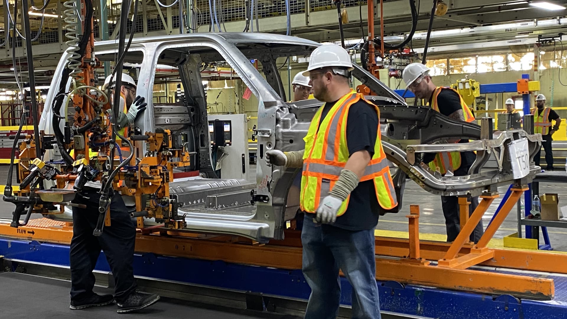 Workers install door hinges to the body shell of a prototype Endurance electric pickup truck on June 21, 2021 at Lordstown Motors' assembly plant in Ohio.