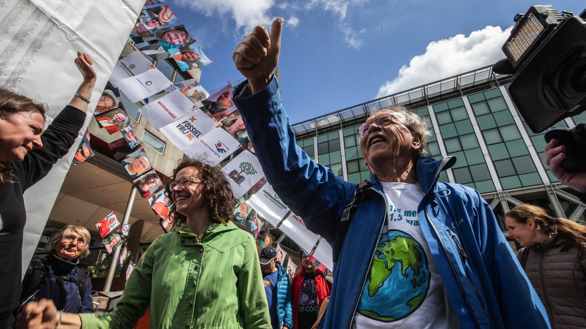 Members of the environmental group MilieuDefensie celebrate the verdict of the Dutch environmental organisation's case against Royal Dutch Shell Plc, outside the Palace of Justice courthouse in The Hague, Netherlands, on Wednesday, May 26, 2021. Shell was ordered by a Dutch court to slash its emissions harder and faster than planned, dealing a blow to the oil giant that could have far reaching consequences for the rest of the global fossil fuel industry.