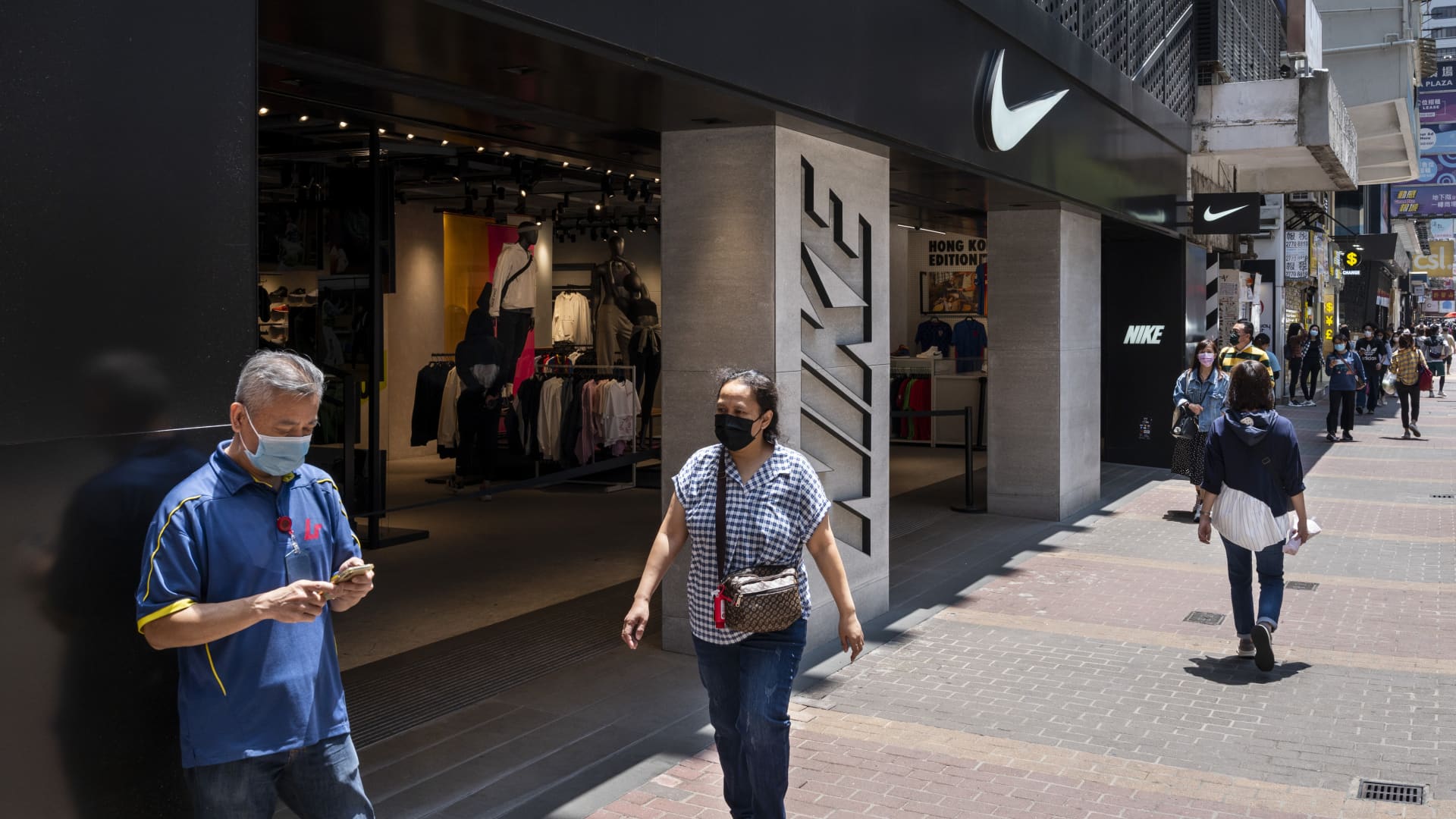 Pedestrians walk past the American multinational sport clothing brand, Nike store and its logo seen in Hong Kong.