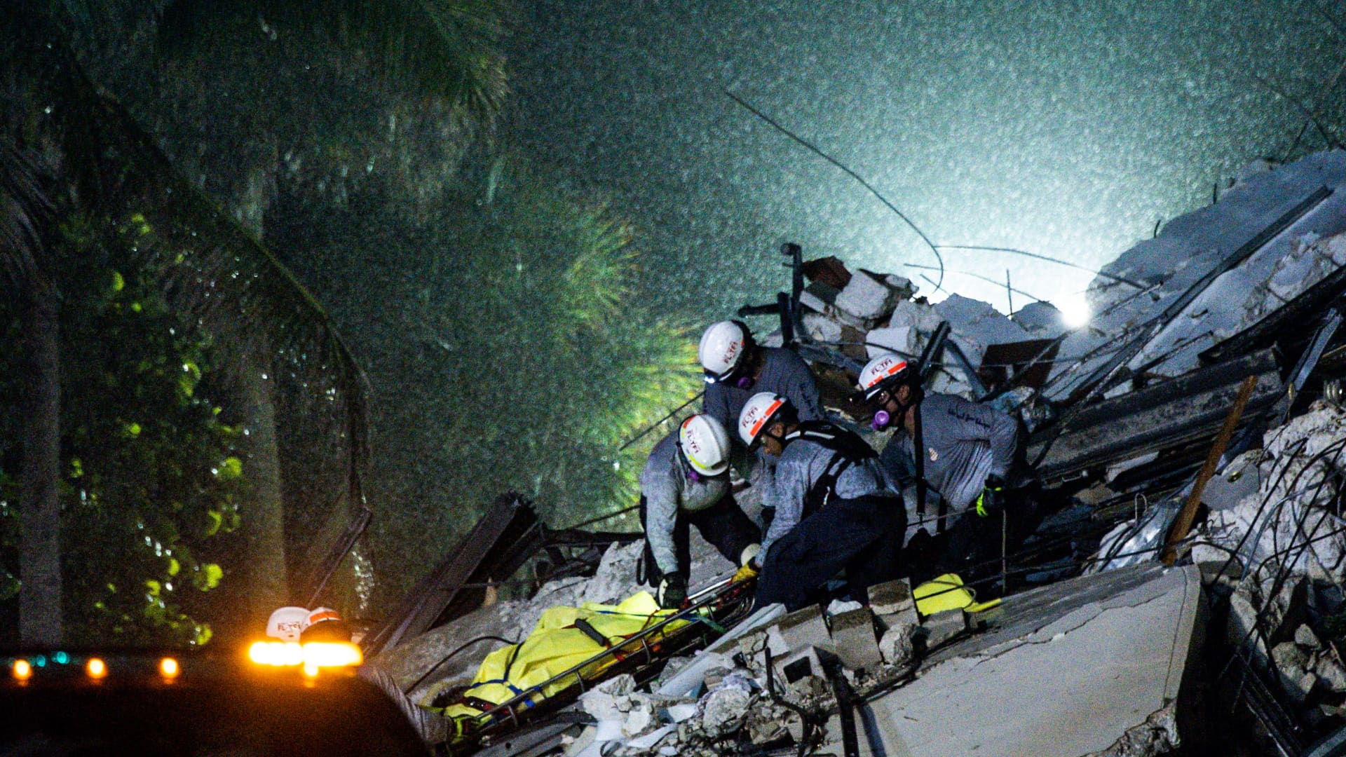 Search and Rescue personnel pull a body out of the rubble after the partial collapse of the Champlain Towers South in Surfside, north of Miami Beach, on June 24, 2021.