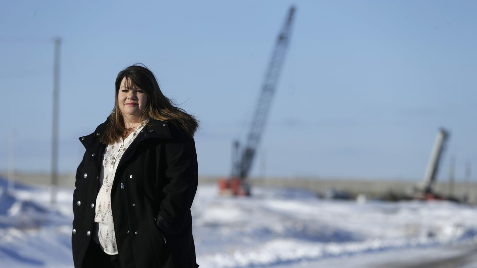 Kim Mahoney stands outside her home near the construction at Foxconn's manufacturing facility in February 2020, in Mount Pleasant, Wisconsin.