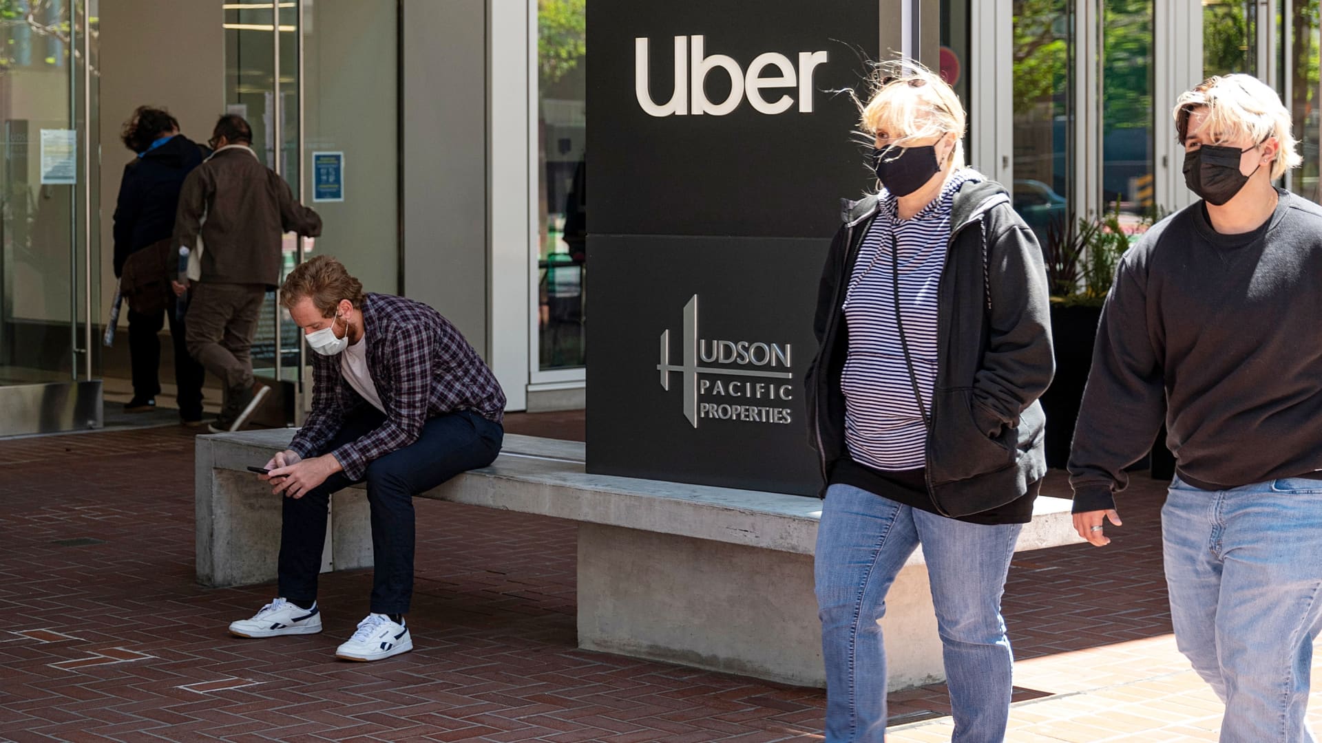 People wear protective masks in front of Uber Technologies Inc. headquarters in San Francisco, California, U.S., on Wednesday, June 9, 2021.