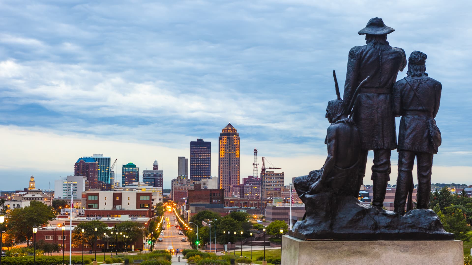 Downtown Des Moines, Iowa with the Pioneers of the Territory statue in the foreground.