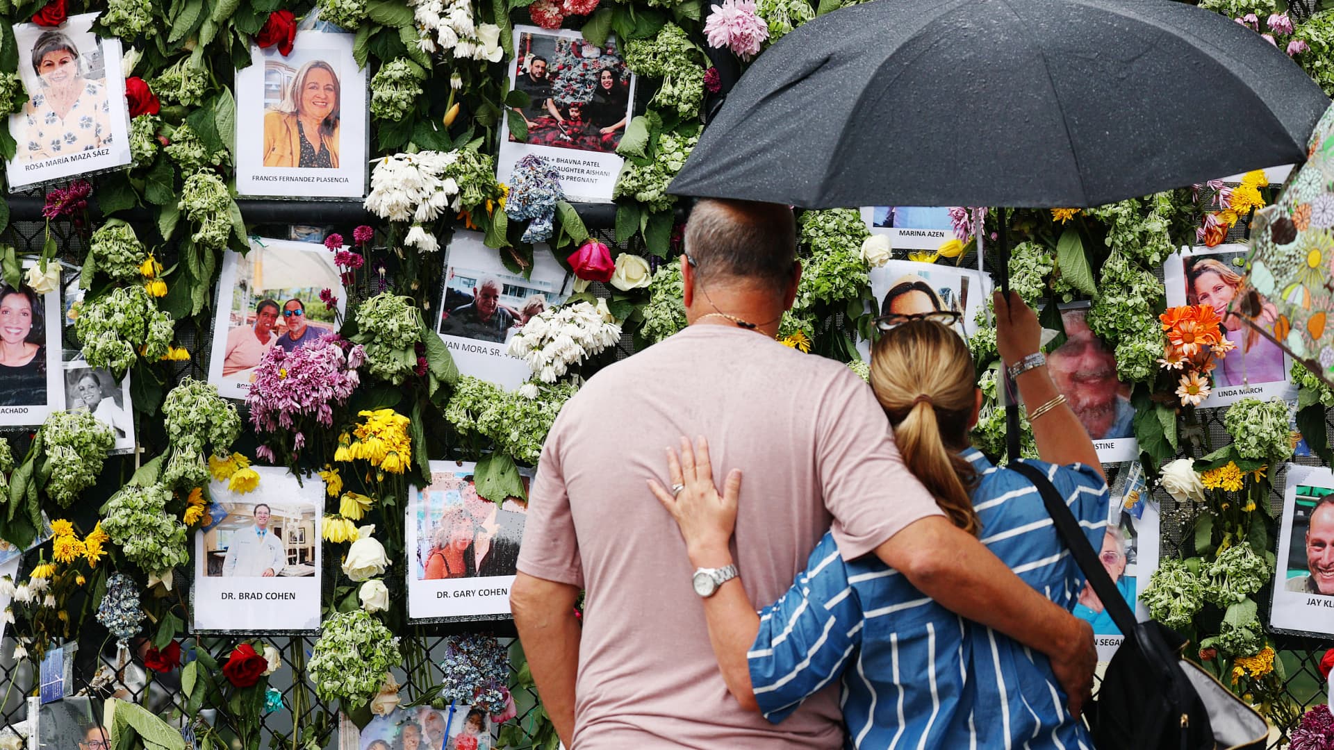 People look at a memorial that has pictures of some of the missing from the partially collapsed 12-story Champlain Towers South condo building on June 30, 2021 in Surfside, Florida.