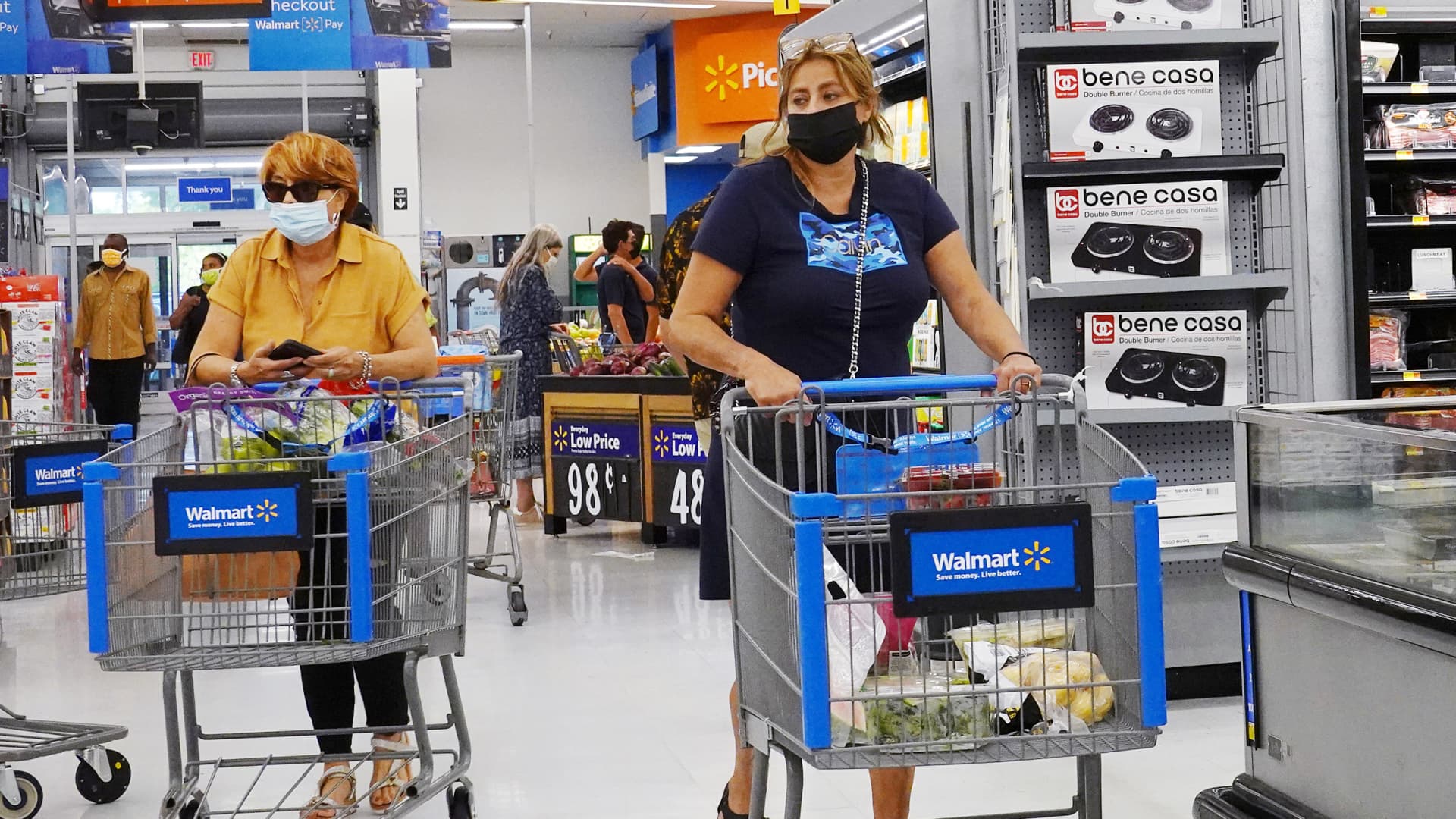 People wearing protective masks shop in a Walmart store on May 18, 2021 in Hallandale Beach, Florida.