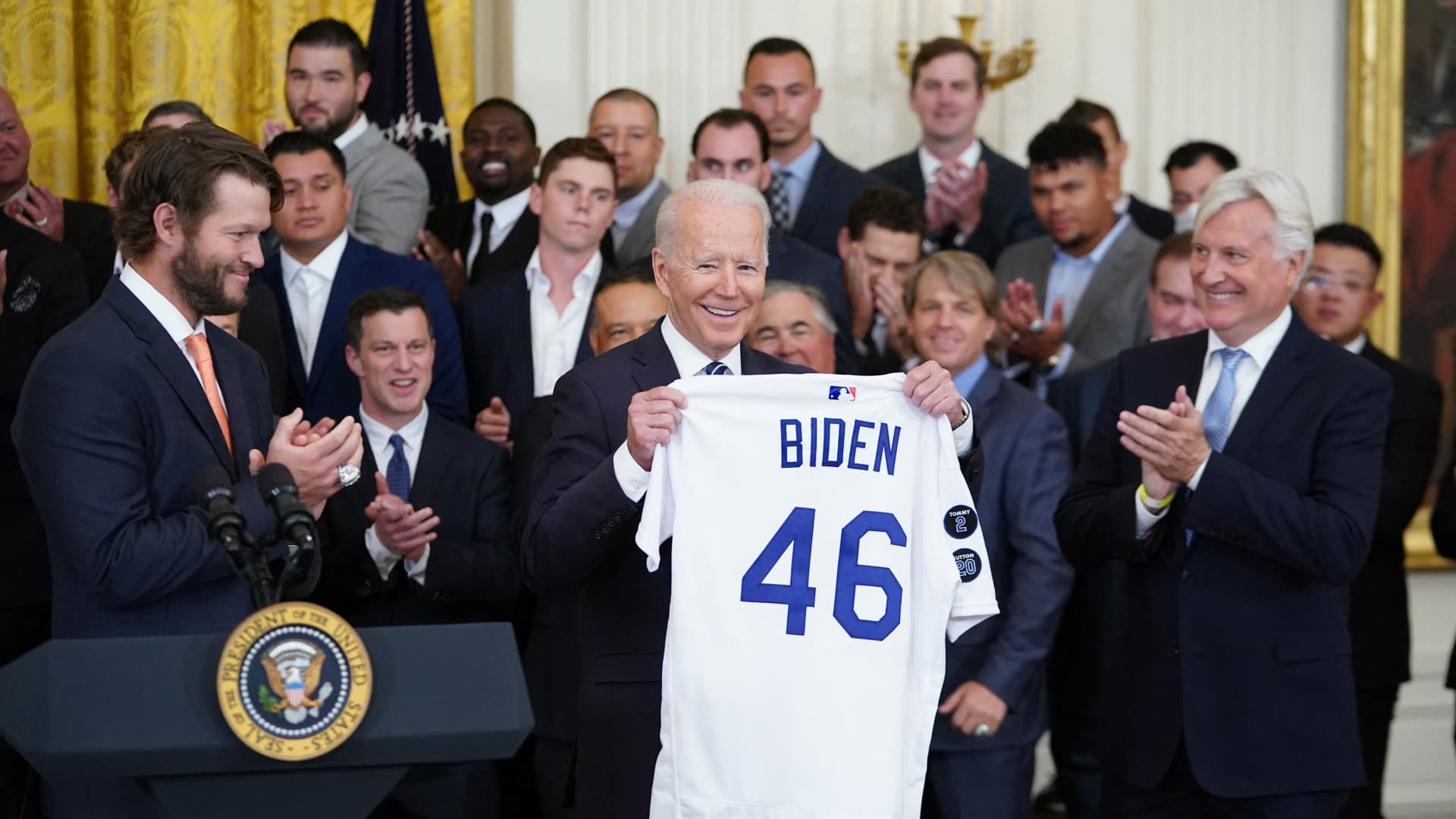 US President Joe Biden holds up a Los Angeles Dodgers team baseball jersey as he welcomes the 2020 World Series Champions during a ceremony in the East Room of the White House in Washington, DC on July 2, 2021.