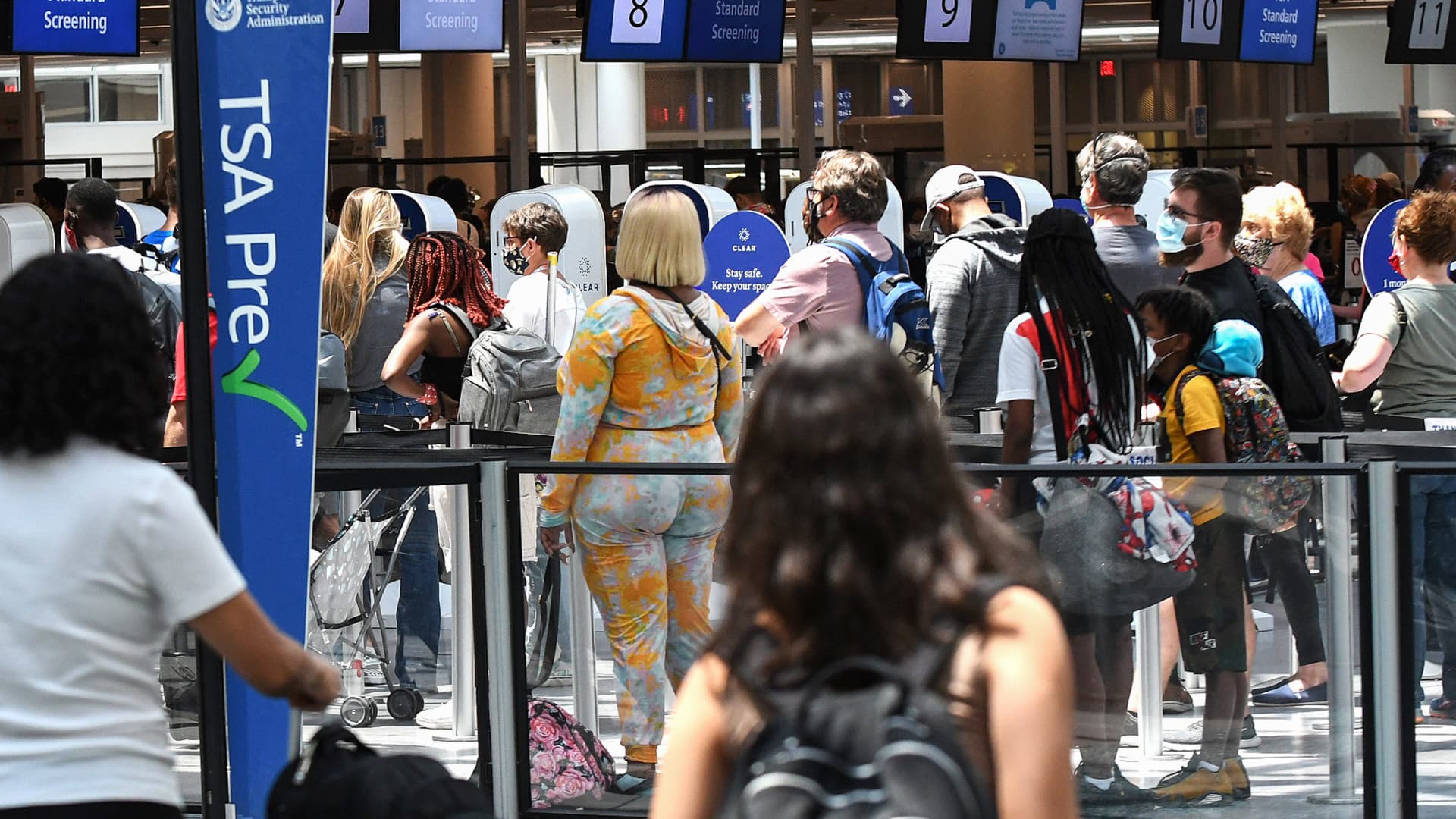 Travelers wait in line at a Transportation Security Administration (TSA) screening checkpoint at Orlando International Airport in May, 2021.