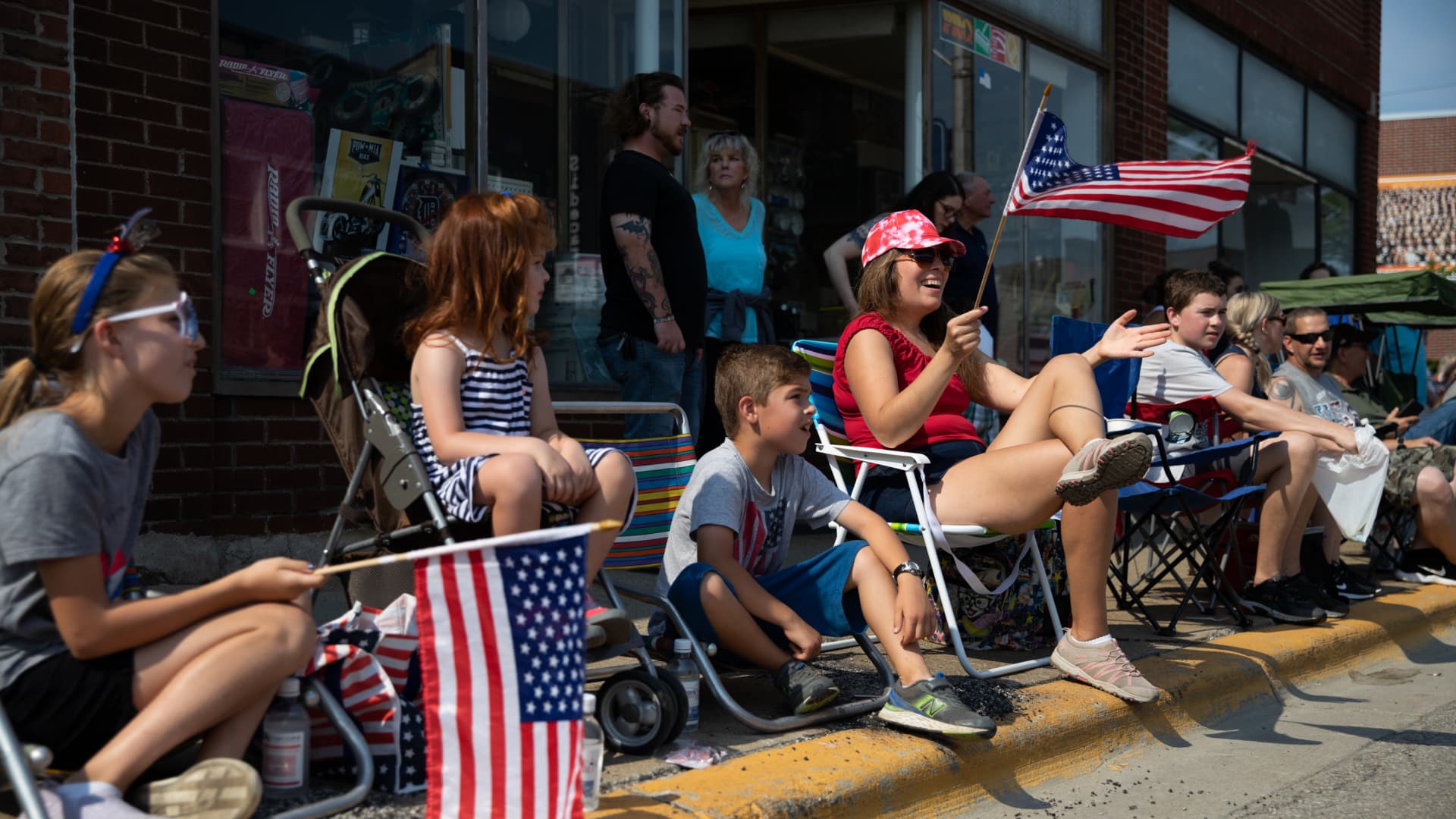 Residents line up with chairs on the side of the street as they watch an Independence Day celebration parade on July 4, 2021 in Brighton, Michigan.