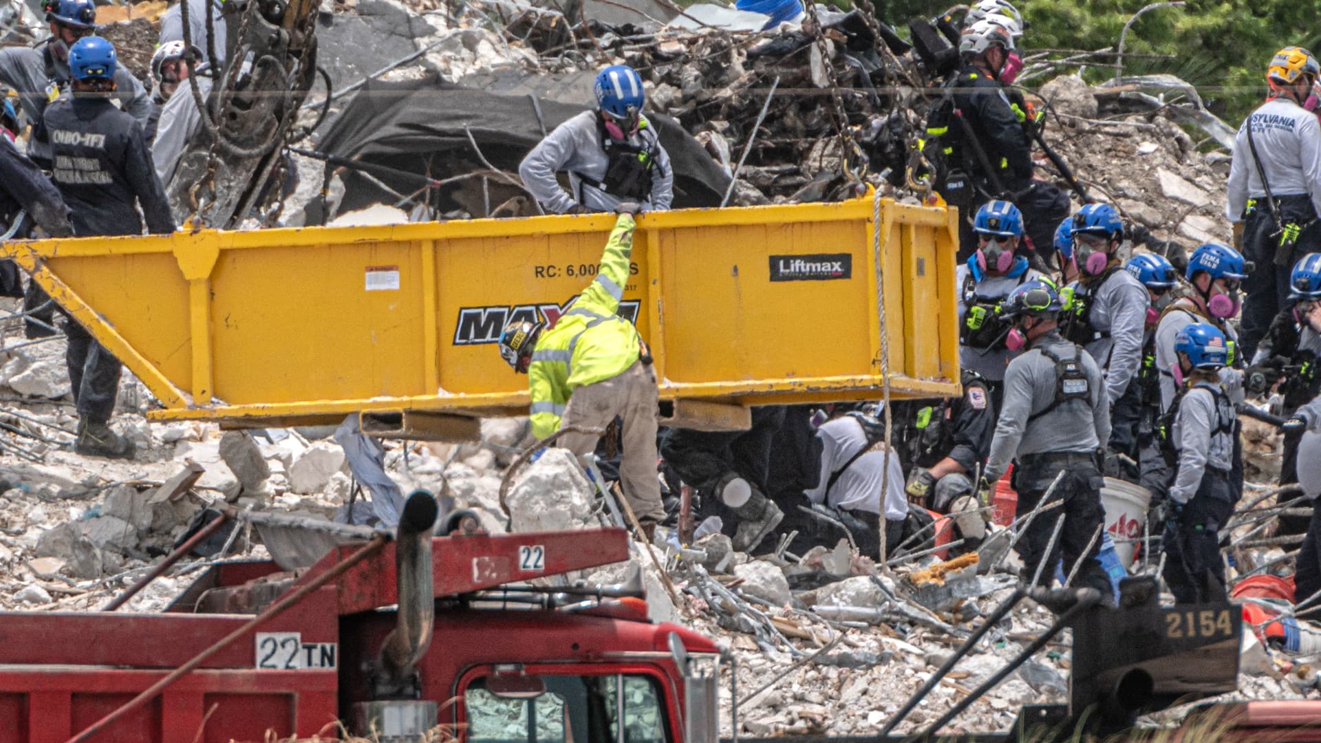 After a brief stop to demolish the standing debris, Search and Rescue personnel continue working in the rubble pile of the partially collapsed 12-story Champlain Towers South condo on July 5, 2021 in Surfside, Florida.