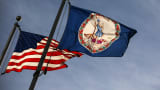 The Virginia State flag and the American flag fly near the Virginia State Capitol.