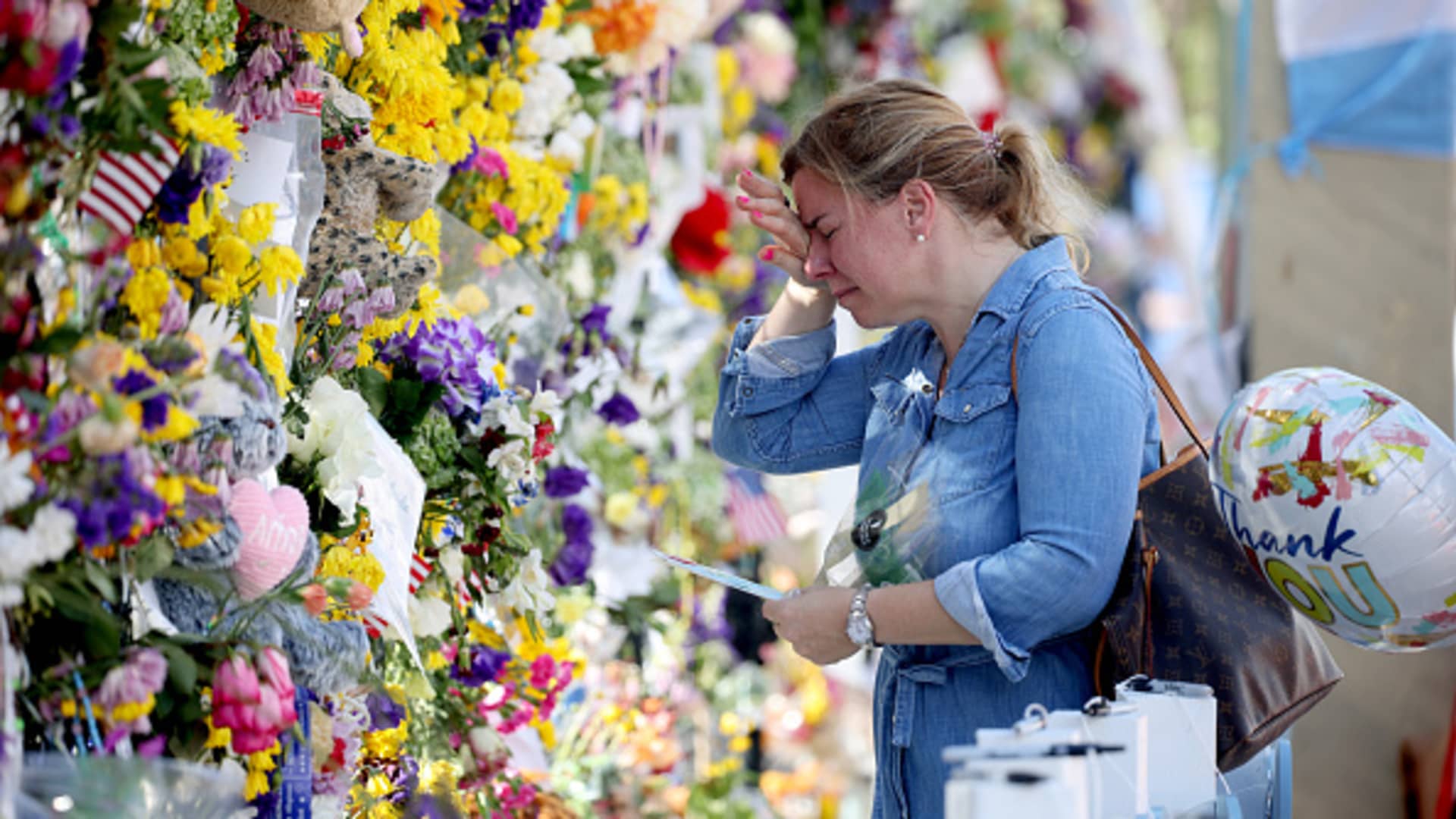 Laura Solla weeps as she places flowers near the memorial site for victims of the collapsed 12-story Champlain Towers South condo building on July 08, 2021 in Surfside, Florida.