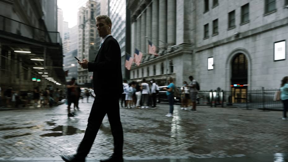 People walk along Wall Street in the rain on July 08, 2021 in New York City.