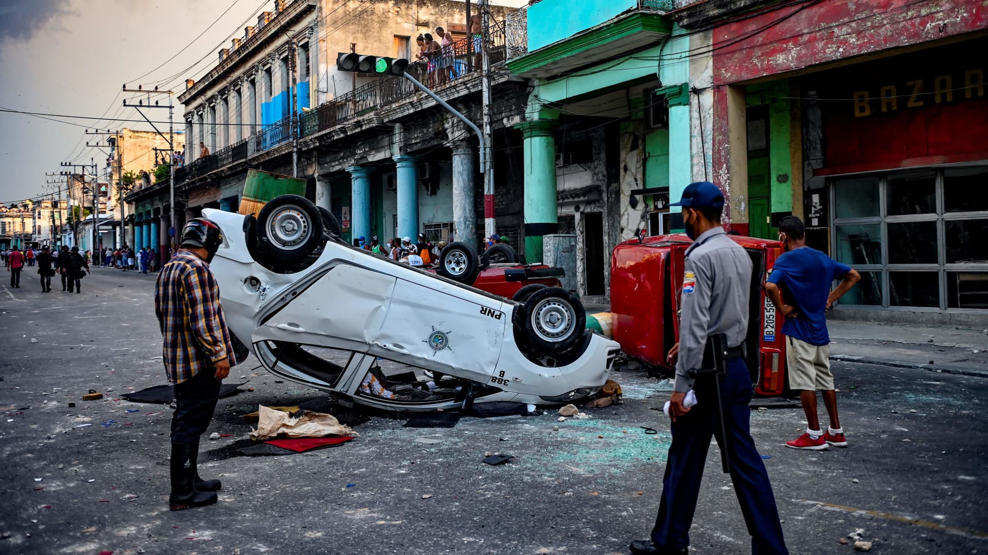 Police cars are seen overturned in the street in the framework of a demonstration against Cuban President Miguel Diaz-Canel in Havana, on July 11, 2021.