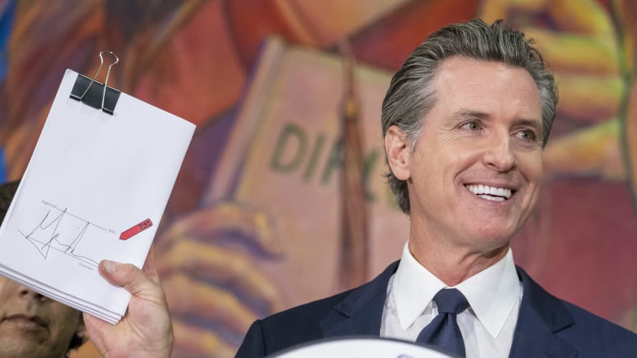 California Governor Gavin Newsom holds a copy of the California State budget after ceremonially signing it during a rally in Los Angeles, Tuesday, July 13, 2021.