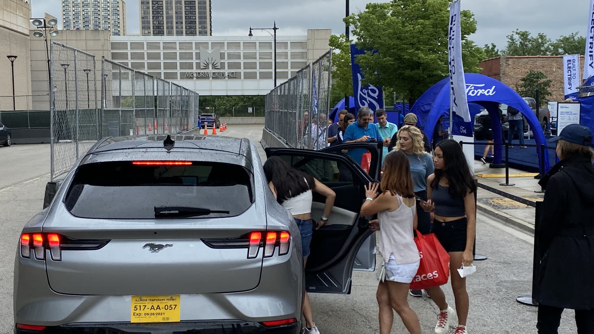 Attendees of the Chicago Auto Show on July 15, 2021 get into a Ford Mustang Mach-E for a test ride in the electric crossover outside of the McCormick Place Convention Center.