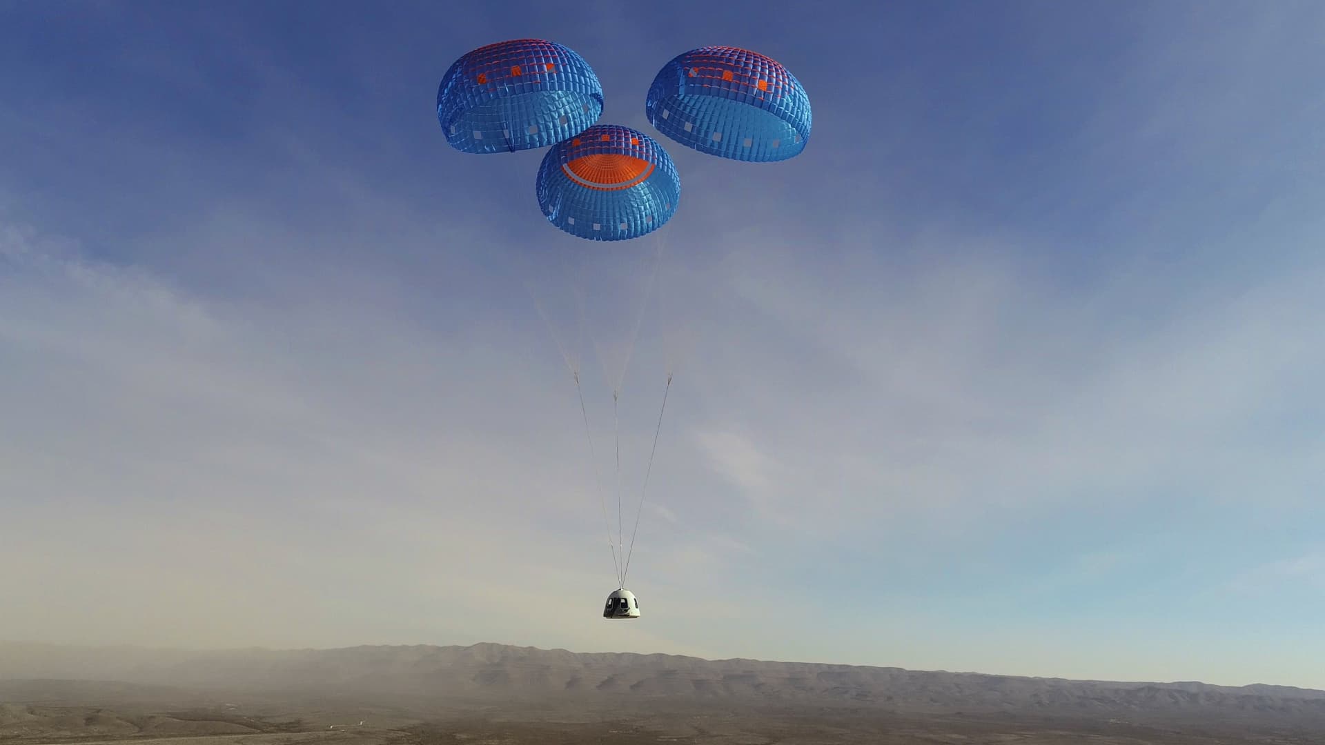 The New Shepard capsule returns under three parachutes for landing during the NS-14 test flight in January 2021.