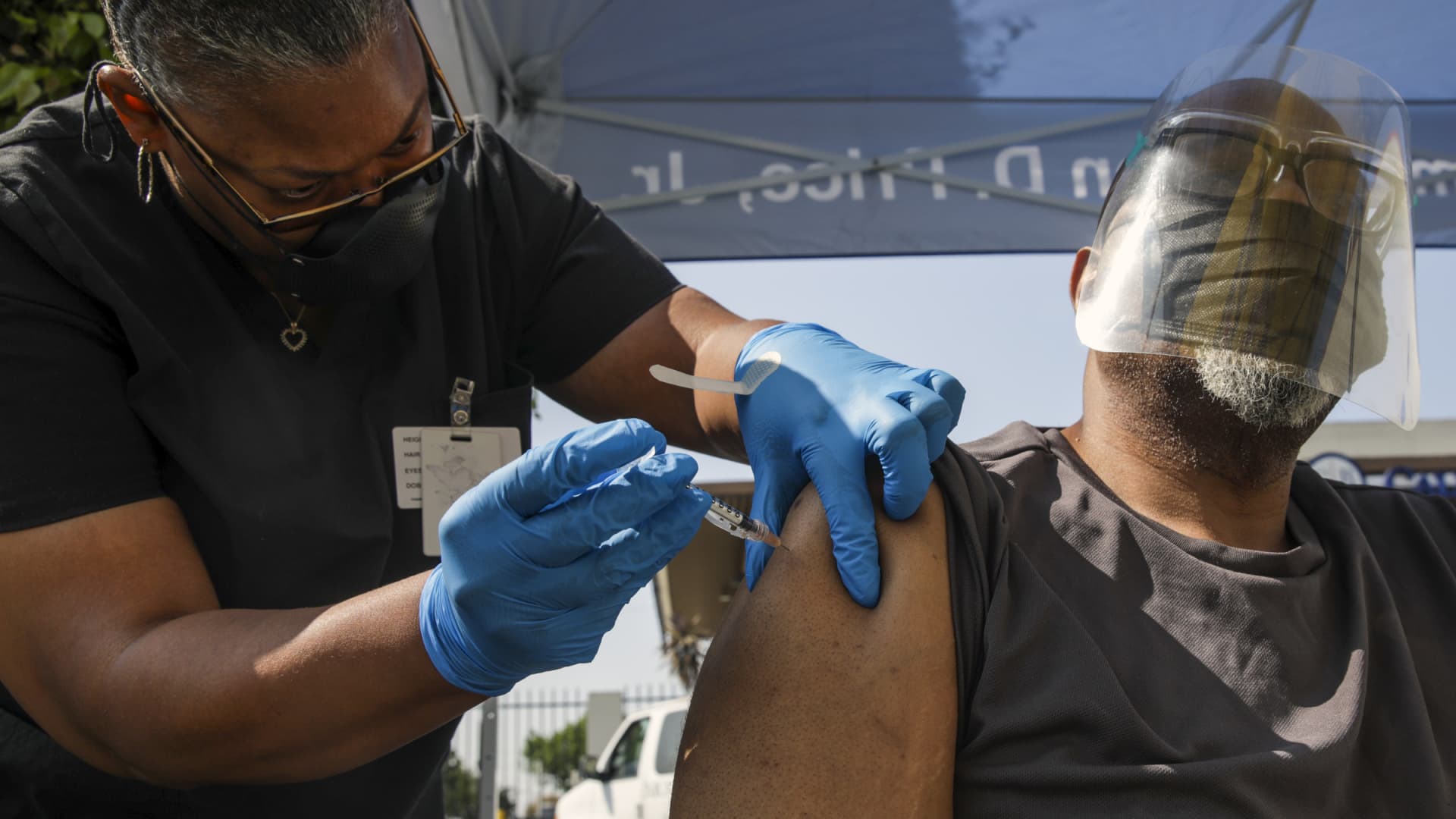 Eon Walk, left, administers a Pfizer-BioNTech vaccine to Daryl Black at a mobile COVID-19 vaccine clinic, hosted by Mothers In Action in collaboration with L.A. County Department of Public Health at Mothers in Action on Friday, July 16, 2021 in Los Angeles, CA.
