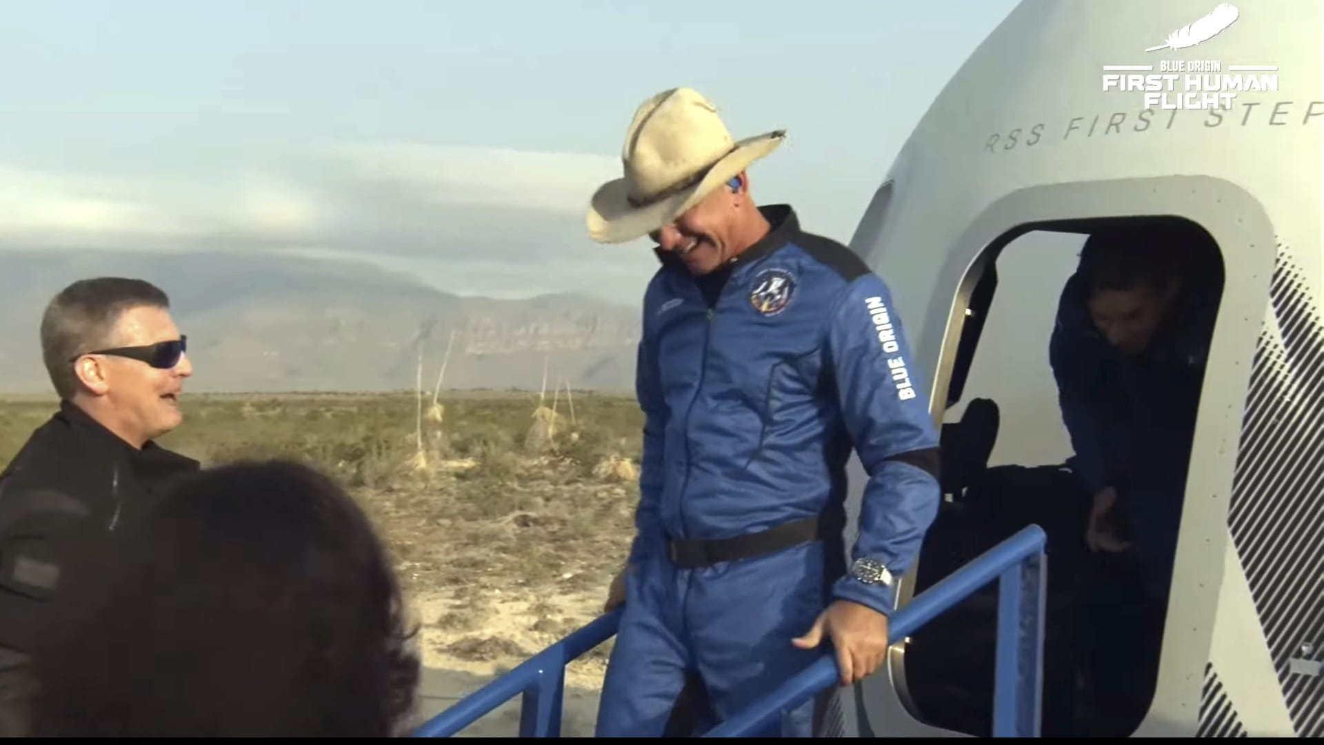 This photo provided by Blue Origin, Jeff Bezos, founder of Amazon and space tourism company Blue Origin, exits the Blue Origin's New Shepard capsule after it parachuted safely down to the launch area with passengers Mark Bezos, Oliver Daemen and Wally Funk, near Van Horn, Texas, Tuesday, July 20, 2021.