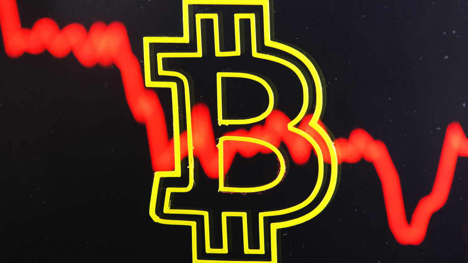 A bitcoin sign with a graph pictured in the background.