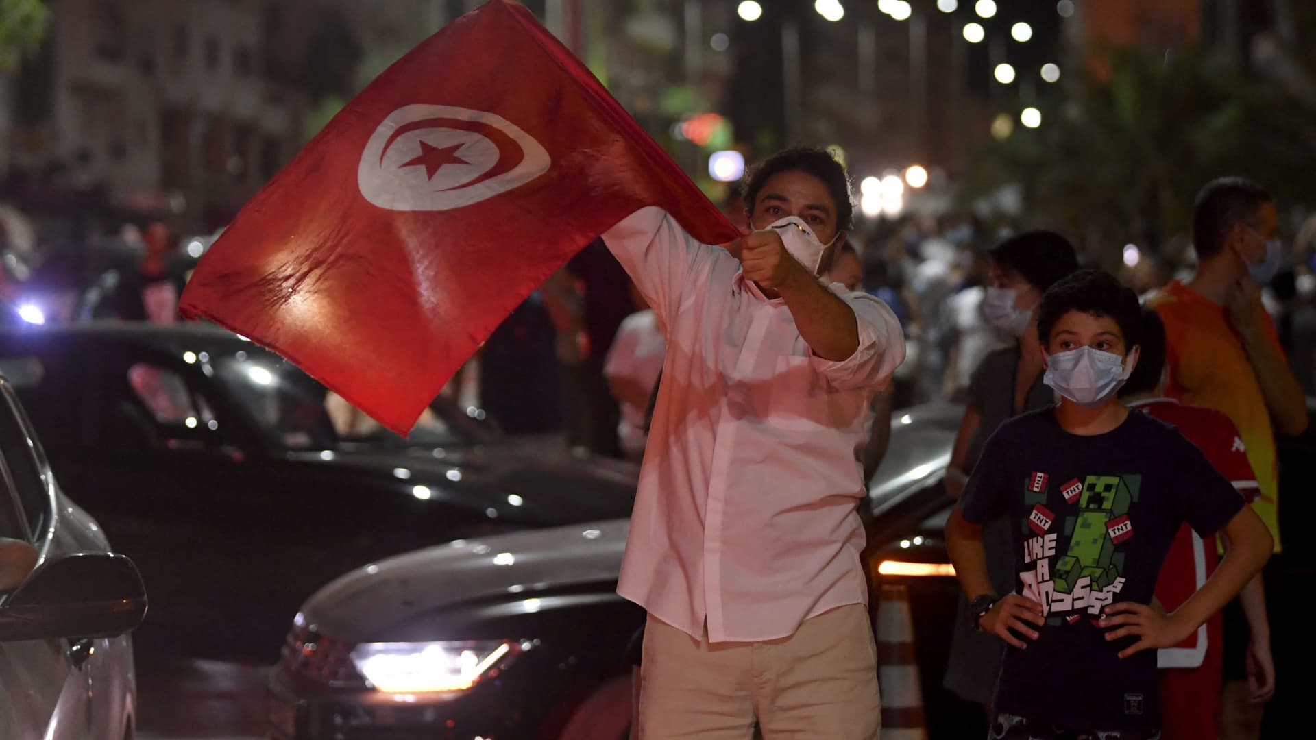 People celebrate in the street after Tunisian President Kais Saied announced the suspension of parliament and the dismissal of the prime minister in Tunis on July 25, 2021, after a day of nationwide protest.